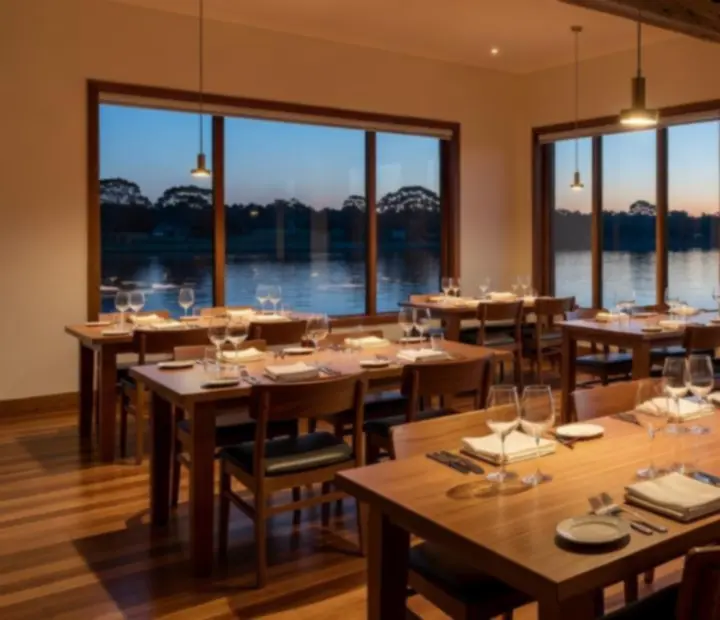 Warmly lit Australian riverside restaurant interior at Potand Platter with linen-dressed tables and soft timber details.