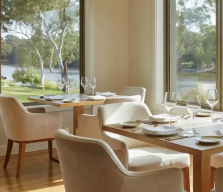Warmly lit Australian riverside dining room set for evening service at Potand Platter